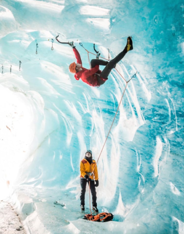 Person ice climbing while another belays